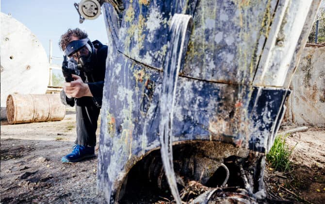 man achter blauw object met airsoft gun gericht