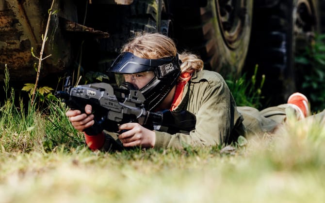 vrouw airsoften kruipt op de gras