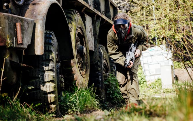 airsoft speler loopt langs grote banden