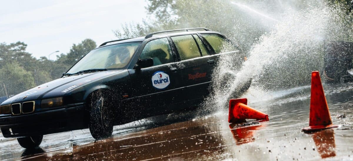 driftauto slaat oranje kegel omver met spattend water