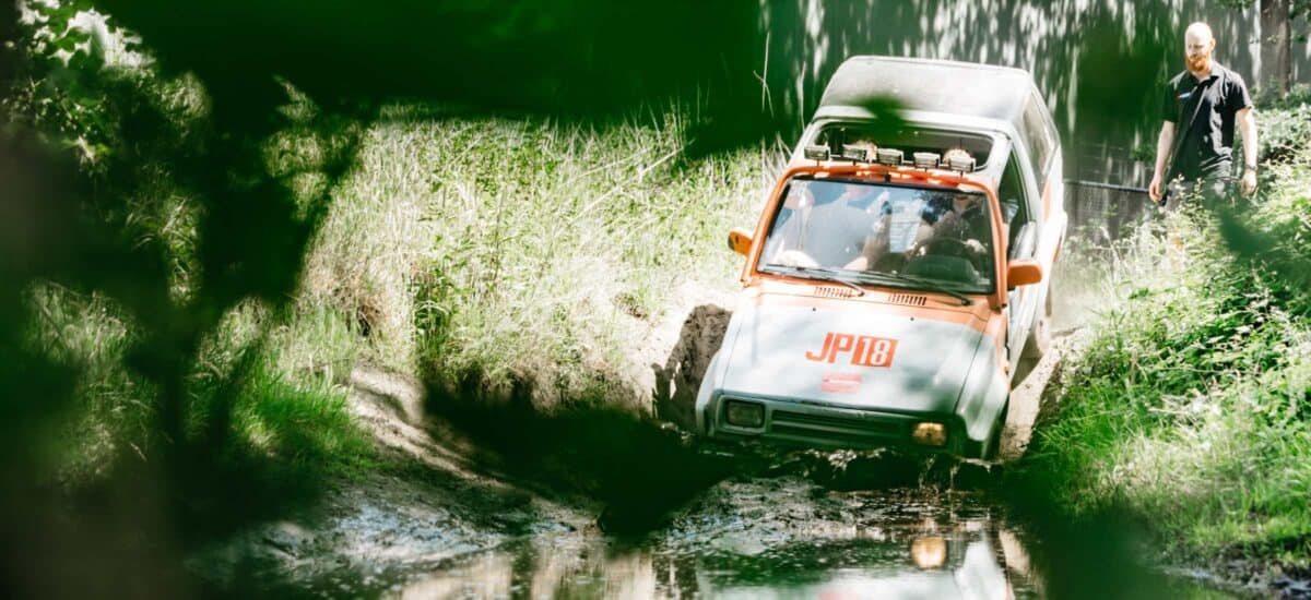 offroad auto rijdt water in tussen gras