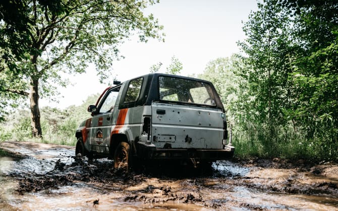 Offroad auto rijdt weg in modder