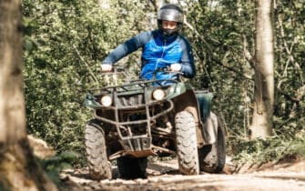 man met blauwe jas quad rijden