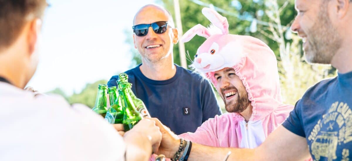 groep met man in konijnenpak proosten bier flesjes